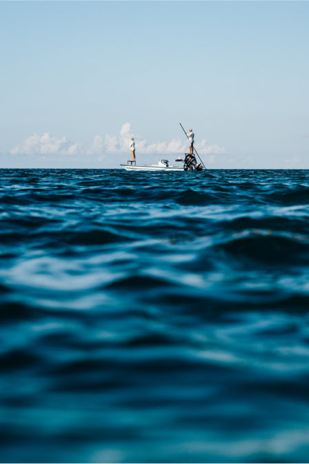 2 fisherman on a boat in the ocean